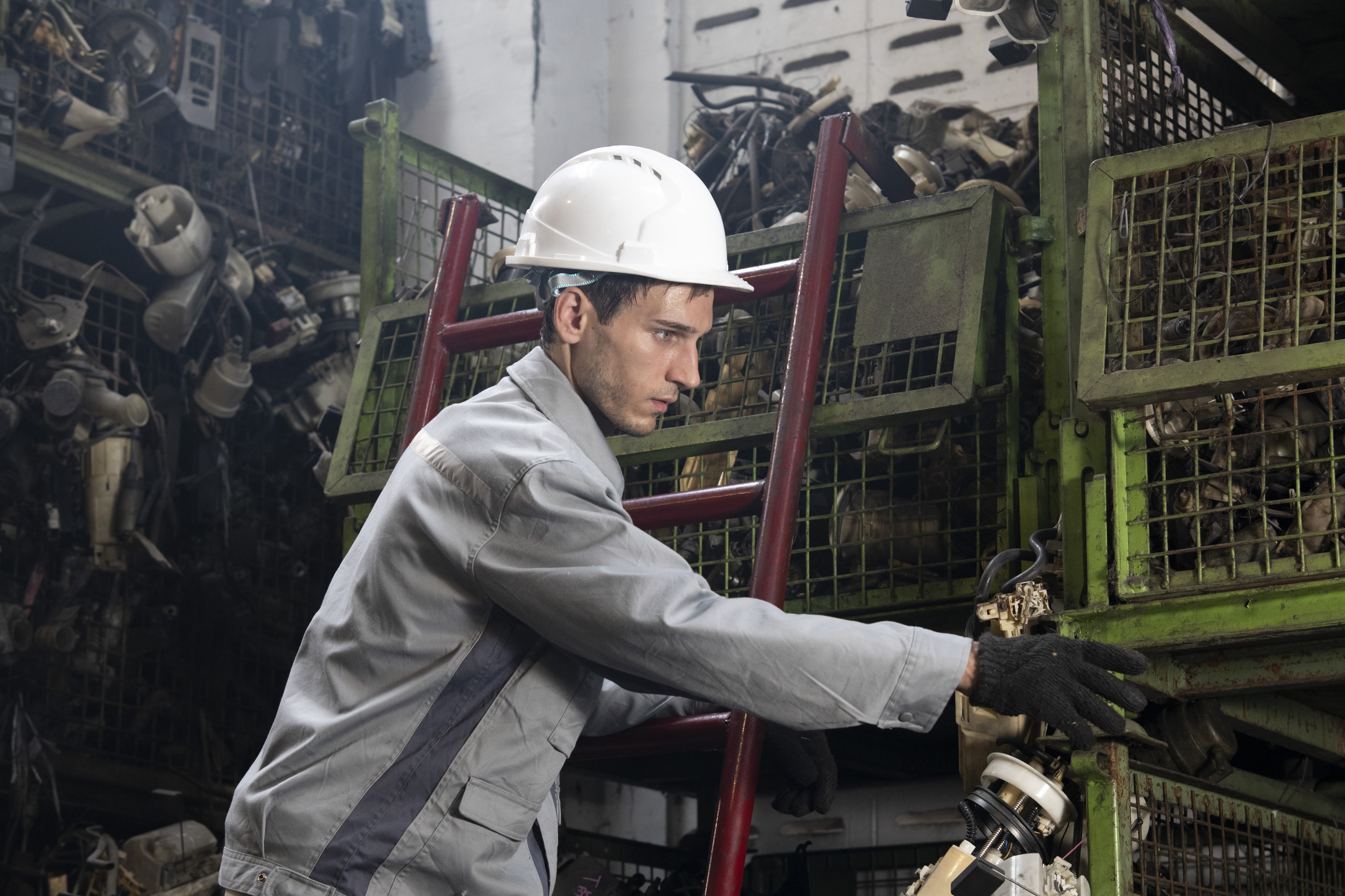 Technician white man worker working and checking in garage scrap yard car workshop warehouse.